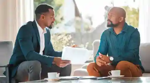Advisor sitting on a client's couch talking